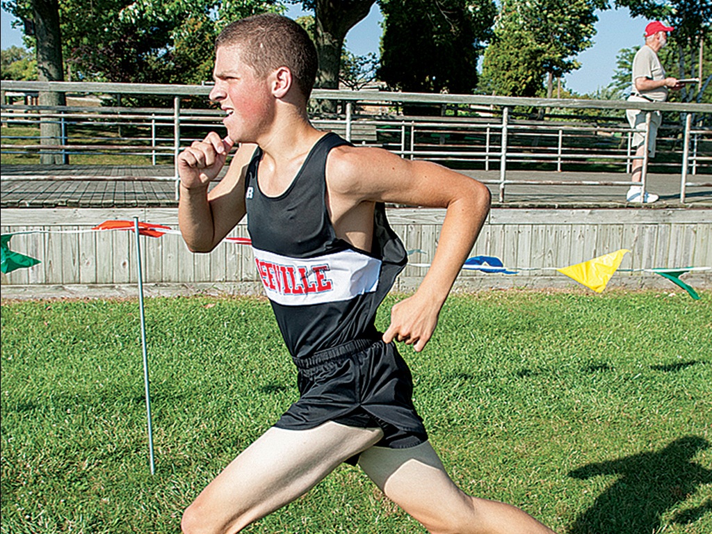 Joe Manfreda running in a cross country meet wearing his Roseville high school jersey